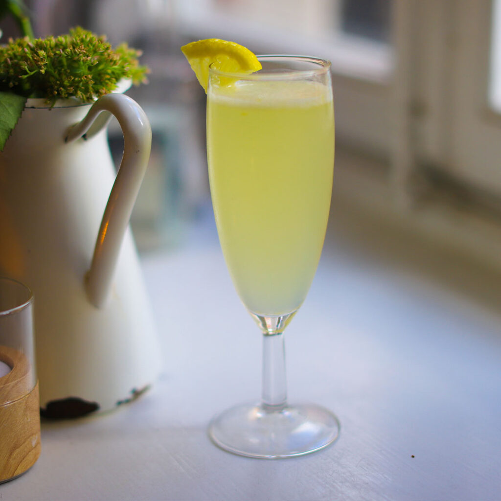 Francuski koktajl French 75 na bazie ginu, wina musującego, soku z cytryny i syropu cukrowego